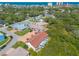 An aerial view showcases the property nestled amongst mature trees with views of the ocean and city skyline at 731 Laurel Bay Cir, New Smyrna Beach, FL 32169