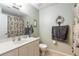 Well-lit bathroom featuring vanity, toilet, shower and coastal decorations on a green wall at 731 Laurel Bay Cir, New Smyrna Beach, FL 32169