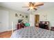 Comfortable bedroom with ceiling fan, hardwood floors, white metal bed frame, and adjacent desk area at 731 Laurel Bay Cir, New Smyrna Beach, FL 32169