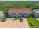 A front aerial view of a two-story townhouse showing off brick driveway and mature tropical landscaping at 731 Laurel Bay Cir, New Smyrna Beach, FL 32169