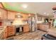 Well-lit kitchen featuring stainless steel appliances, granite countertops, and custom wood cabinetry at 731 Laurel Bay Cir, New Smyrna Beach, FL 32169