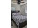 Bedroom featuring a dark wood bed frame, patterned bedding, ceiling fan, and bright windows at 808 Catherine Ave, Daytona Beach, FL 32117