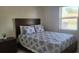 Cozy bedroom with a dark wood bed frame, patterned bedding, and a bright window at 808 Catherine Ave, Daytona Beach, FL 32117