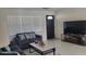 Cozy living room with a gray sofa, large windows, and a decorative front door at 808 Catherine Ave, Daytona Beach, FL 32117
