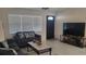 Cozy living room with a gray sofa, large windows, and a decorative front door at 808 Catherine Ave, Daytona Beach, FL 32117
