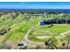 Aerial view of a golf course with lush green fairways and a pond at 103 Sea St, New Smyrna Beach, FL 32168