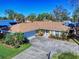 One-story home with brown roof, driveway, and palm trees at 103 Sea St, New Smyrna Beach, FL 32168