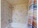 Bathroom with a shower/tub combo and marble-look walls at 103 Sea St, New Smyrna Beach, FL 32168