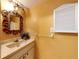 Small bathroom with sink, toilet, and decorative mirror at 103 Sea St, New Smyrna Beach, FL 32168