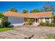 Brick house with a brown roof, white garage door, and well-maintained landscaping at 103 Sea St, New Smyrna Beach, FL 32168