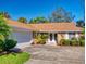 Brick house with a brown roof, white garage door, and well-maintained landscaping at 103 Sea St, New Smyrna Beach, FL 32168