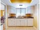 White kitchen with granite countertops and double sink at 103 Sea St, New Smyrna Beach, FL 32168