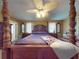 Main bedroom with a wooden post bed, ceiling fan, and plenty of natural light at 103 Sea St, New Smyrna Beach, FL 32168