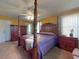 Main bedroom with a large wooden post bed, ceiling fan and ample closet space at 103 Sea St, New Smyrna Beach, FL 32168