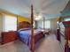 Spacious main bedroom with a large wooden post bed and fireplace at 103 Sea St, New Smyrna Beach, FL 32168