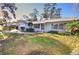 Front view of a ranch house with a white brick exterior and well-maintained lawn at 1120 Marcel St, New Smyrna Beach, FL 32168