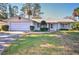 Ranch-style home with white brick exterior, attached garage, and mature landscaping at 1120 Marcel St, New Smyrna Beach, FL 32168