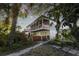 Two-story home with charming front exterior, lush landscaping, and wooden gates at 1324 N Peninsula Ave, New Smyrna Beach, FL 32169