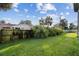 Sunny backyard with lush lawn, wooden fence, and tropical plants at 142 Sandpiper Ridge Dr, Ormond Beach, FL 32176