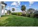 Landscaped backyard with grassy area and palm trees at 142 Sandpiper Ridge Dr, Ormond Beach, FL 32176