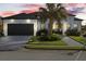 Modern home exterior at dusk, featuring a dark garage door and landscaping at 142 Sandpiper Ridge Dr, Ormond Beach, FL 32176