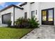 Modern front entrance with dark double doors and stone walkway at 142 Sandpiper Ridge Dr, Ormond Beach, FL 32176