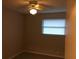 Small bedroom with ceiling fan, window, and light walls at 1500 Wildrose Ln, Daytona Beach, FL 32117