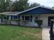 House exterior featuring a blue and beige color scheme, landscaping, and a walkway at 1500 Wildrose Ln, Daytona Beach, FL 32117