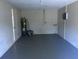 Unfinished garage with grey floor and water heater at 1500 Wildrose Ln, Daytona Beach, FL 32117