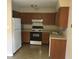 Galley-style kitchen with wood cabinets and white appliances at 1500 Wildrose Ln, Daytona Beach, FL 32117