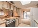 Kitchen with light-colored cabinets, a stove, and access to a back patio at 1820 Sabal Palm Dr, Edgewater, FL 32132