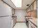 Clean and bright kitchen featuring white appliances and floral wallpaper at 1820 Sabal Palm Dr, Edgewater, FL 32132