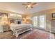 Spacious bedroom with king bed, tiled floors, and French doors at 1846 Turnbull Lakes Dr, New Smyrna Beach, FL 32168