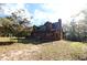 Log cabin home with green roof, nestled in trees at 187 N Samsula Dr, New Smyrna Beach, FL 32168