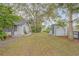 Backyard view of house with shed and landscaping at 2304 Date Palm Dr, Edgewater, FL 32141