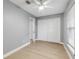 Light grey bedroom with white closet doors and wood flooring at 2304 Date Palm Dr, Edgewater, FL 32141