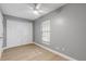 Simple bedroom with ceiling fan, grey walls, and white closet doors at 2304 Date Palm Dr, Edgewater, FL 32141