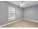 Bedroom with ceiling fan, light grey walls, and wood flooring at 2304 Date Palm Dr, Edgewater, FL 32141