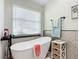 Bathroom with freestanding bathtub, wood-look tile, and modern fixtures at 2322 Melonie Trl, New Smyrna Beach, FL 32168