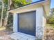 Modern storage shed with dark gray door and stone accents at 2322 Melonie Trl, New Smyrna Beach, FL 32168