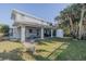 Outdoor patio with seating area, covered by a pergola, and lush tropical landscaping at 239 Kirkland Rd, New Smyrna Beach, FL 32169