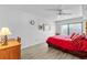 Main bedroom with a ceiling fan, red bedding, and wood built-ins at 3001 S Atlantic Ave # 503, New Smyrna Beach, FL 32169