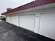 Exterior view of four garages with white doors at 3001 S Atlantic Ave # 503, New Smyrna Beach, FL 32169