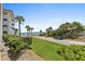 Ocean view from grassy area with palm trees and a car at 3001 S Atlantic Ave # 503, New Smyrna Beach, FL 32169