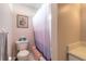 Simple bathroom with white vanity and purple shower curtain at 3015 Queen Palm Dr, Edgewater, FL 32141