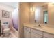 Bathroom with tub, white vanity, and purple shower curtain at 3015 Queen Palm Dr, Edgewater, FL 32141