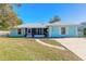 Light teal house with metal roof, walkway, and well-maintained lawn at 3015 Queen Palm Dr, Edgewater, FL 32141