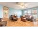 Living room with hardwood floors, light blue walls, and a view of the pool at 3015 Queen Palm Dr, Edgewater, FL 32141