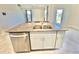 Kitchen island with double sink, dishwasher, and granite countertop at 3035 Meleto Blvd, New Smyrna Beach, FL 32168