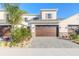 Two-story townhome with a brown garage door and landscaped front yard at 3046 Isles Way, New Smyrna Beach, FL 32168